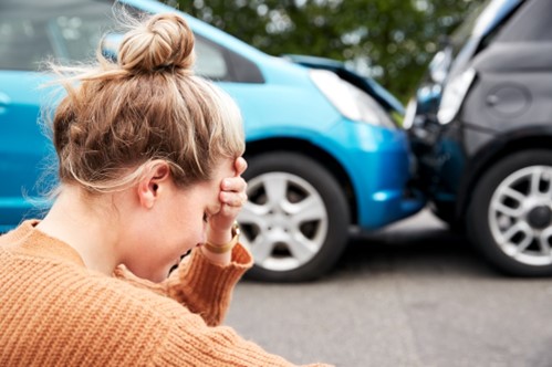 A woman holds her head in her hands following a car accident