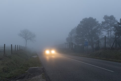 Car driving through fog