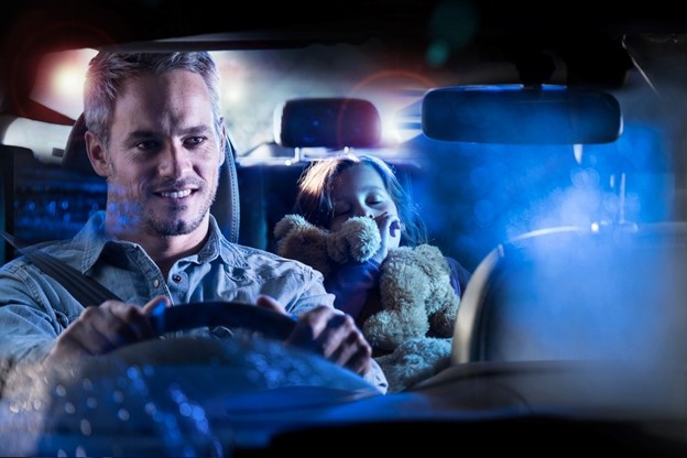 Man driving at night with girl in back seat